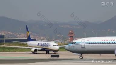 荷兰皇家航空公司和瑞安航空公司的飞机滑行到巴塞罗那机场的登机口，商用飞机准备起飞